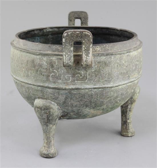 A Chinese archaic bronze tripod ritual food vessel, Ding, Eastern Zhou dynasty, 26.5cm wide, holes to base, cover lacking